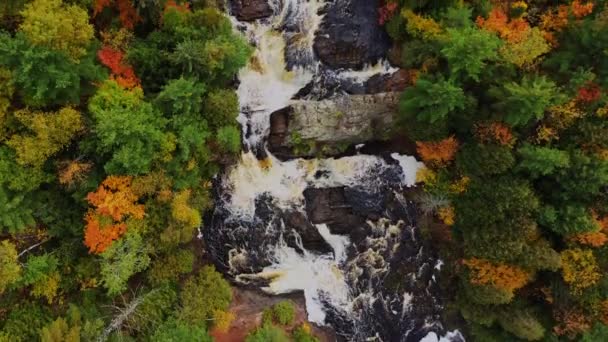 Bellissimo autunno guardare giù volo aereo sopra il fiume Patata e Alto Potato Falls con il flusso di acqua pesante a cascata sopra le grandi formazioni rocciose con alberi gialli, arancioni, rossi e verdi sulla riva del fiume — Video Stock