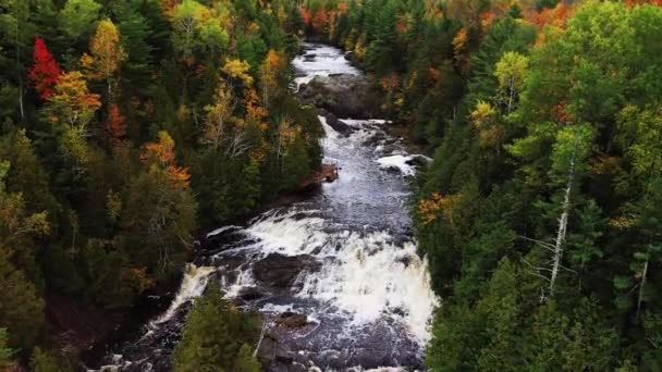 Belle panoramique vers le bas aérien regardant vers le bas de la rivière de la pomme de terre à Upper Potato River Falls descendant à un gros plan en dessous des chutes inférieures que les cascades d'écoulement d'eau lourde sur la surface rocheuse. — Video