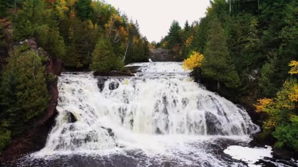 Detailní anténa Dolních brambor River Falls s těžkým proudem vody kaskádovitě stékající po skalnatých útesech k řece dole se stromy lemujícími břeh. — Stock video