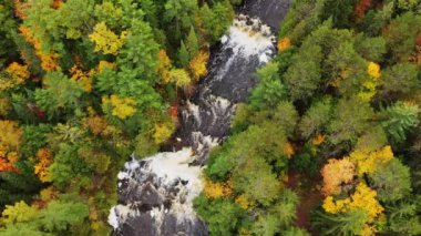 Tyler Forks nehri üzerinde uçan güzel hava ve Brownstone Şelalesi 'nin yukarısında Brownstone Şelaleleri üzerinde renkli sonbahar yaprakları ile Wisconsin Mellen' de sonbaharda nehir kıyılarını kaplayan beyaz su şelaleleri.