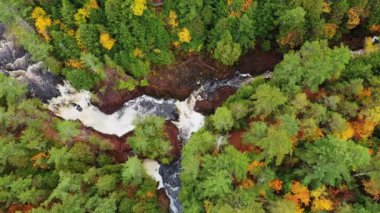Brownstone Şelalesi 'nin üzerinde renkli yapraklar ve sonbaharda Copper Falls Parkı' nda nehir kenarındaki kırmızı kayaların oluşturduğu Kötü Nehir ve Tyler Forks kavşağındaki havadan aşağı güzel bir bakış..