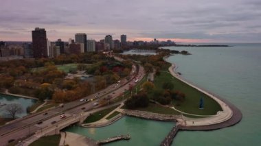 Chicago, IL - 26 Ekim 2020: Lake Shore Drive 'da motorcular, koşucular ve aylaklar Michigan Gölü boyunca sıcak bir sonbahar gününün keyfini çıkarırken trafik geçiyor.