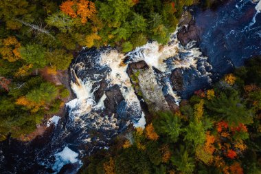 Yukarı Patates Nehri Şelaleleri 'nin çağlayan şelaleleri ve beyaz su akıntılarının Wisconsin' deki yaprak döken ve yemyeşil orman çöllerini keserken çekilmiş güzel bir fotoğrafı..