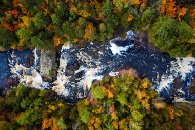 Yukarı Patates Nehri Şelaleleri 'nin çağlayan şelaleleri ve beyaz su akıntılarının Wisconsin' deki yaprak döken ve yemyeşil orman çöllerini keserken çekilmiş güzel bir fotoğrafı..