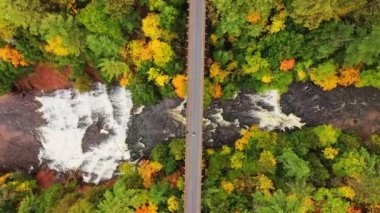 Güzel bir sonbahar havası bakışları bir adamın üstünden Ontonagon Nehri 'ni geçen terk edilmiş bir demiryolu köprüsüne ve aşağıdaki ağaçlardan oluşan bir şelaleyle çevrili Agate Şelalesine iniyor..