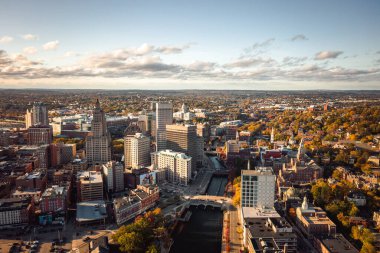 Providence, RI - 21 Ekim 2020: Yüksek binalar, kilise kubbeleri ve Rhode Island State House 'un büyük beyaz kubbesi Providence Nehri boyunca şehir merkezindeki ufuk çizgisini süslüyor..