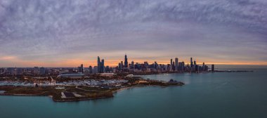 Ufuk boyunca yükselen gökdelen binaları ve güzel turuncu ve mavi günbatımı gökyüzüne sahip kuzeydeki ada ve Michigan Gölü ile geniş açılı Chicago şehri gökyüzü manzarası..