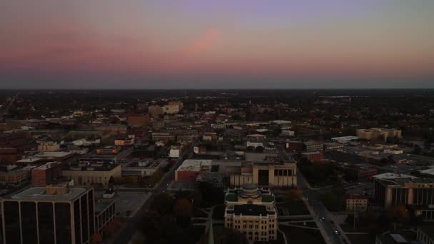 空がピンクと青に変わり 2台の警察車両がライトを点滅しているので 静かな日にトレドのダウンタウンの北の市民センターと商業地区の近所の上に美しい早朝の航空機 — ストック動画