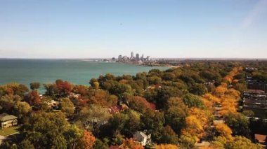 Cleveland, Ohio 'nun yükselen panoramik manzarası gökyüzü güneşli bir sonbahar gününde ufuk çizgisi ve Erie Gölü' nün suyu olan bir yerleşim yerinden yükseliyor..