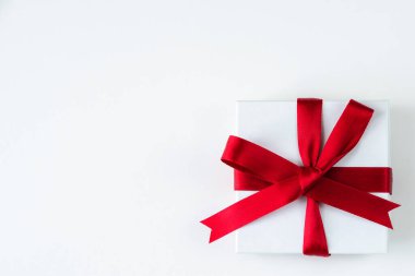 Güzel bir bayram ya da Noel arkaplan resmi. Sağ alt köşede beyaz bir kutuya sarılı küçük kırmızı bir kurdele var. Üstü ve solunda fotokopi alanı var..