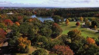 Ağaçların üzerinden geçen güzel bir sonbahar havası klasik beyaz mermer tapınağa doğru uçuyor Providence, Rhode Island 'daki Roger Williams parkında bir göl boyunca müzik yapısına doğru..