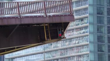 Columbus Drive 'a yakın çekim köprüsü Chicago şehir merkezindeki nehrin üzerindeki yüksek bir binanın önünde yükseliyor..