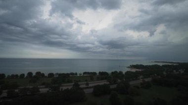 Dalgalanan fırtına bulutlarının hava manzarası Michigan Gölü ve Sahil Yolu 'nun suları üzerinde yağmur ve gök gürültülü fırtınalar eşliğinde gökyüzünde dalgalanan bir hava cephesinin parçası..