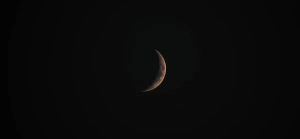 这是一张月牙色和黄色的月牙色的大的 戏剧性的夜间特写照片 其细节包括暗黑天空背景下的月球表面的陨石坑 — 图库照片