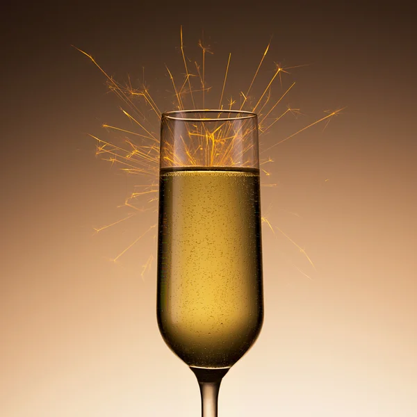 Champagnerglas mit Wunderkerze — Stockfoto