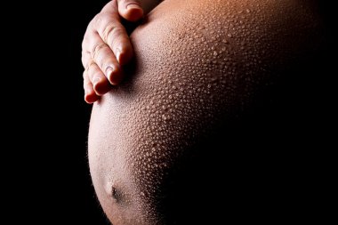 babybauch mit wassertropfen