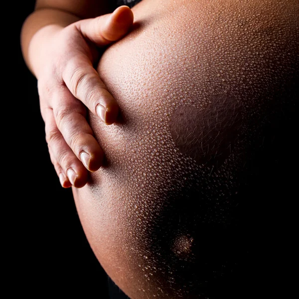 Vientre de mujer embarazada con gotas de agua y forma de corazón — Foto de Stock