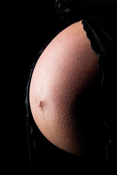 Barriga de mulher grávida com gotas de água — Fotografia de Stock
