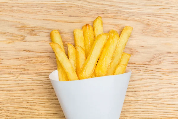 Franse frietjes pommes op houten achtergrond — Stockfoto