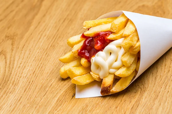 Patatine fritte in un sacchetto con ketchup e maionese — Foto Stock