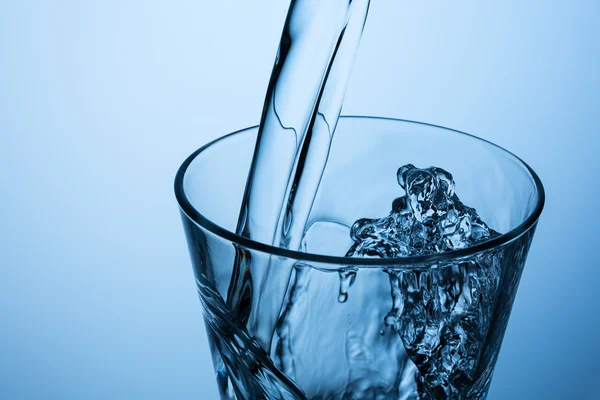 Pouring splashing water in a glass — Stock Photo, Image