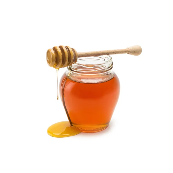 Honey pot with wood stick overflowing Royalty Free Stock Images