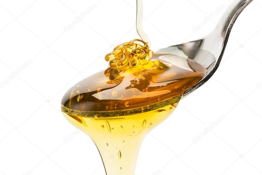 Spoon with pouring honey