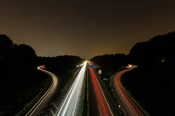 Interchange på natten med lighttrails — Stockfoto