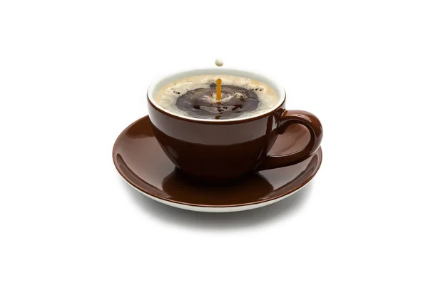 Milk drop falling in a coffee cup — Stock Photo, Image