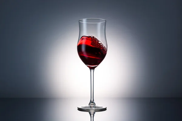 Golf van rode wijn in een glas — Stockfoto