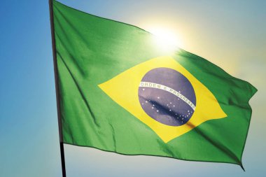 Brezilya bayrağı güneşin önünde rüzgarda dalgalanıyor