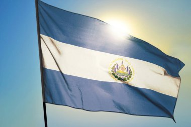 El Salvador bayrağı güneşin önünde rüzgarda dalgalanıyor.