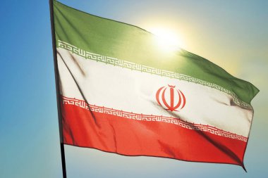 İran bayrağı güneşin önünde rüzgarda dalgalanıyor