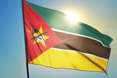 Mozambik bayrağı güneşin önünde rüzgarda dalgalanıyor.
