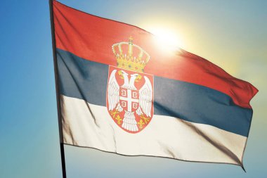 Sırbistan bayrağı güneşin önünde rüzgarda dalgalanıyor