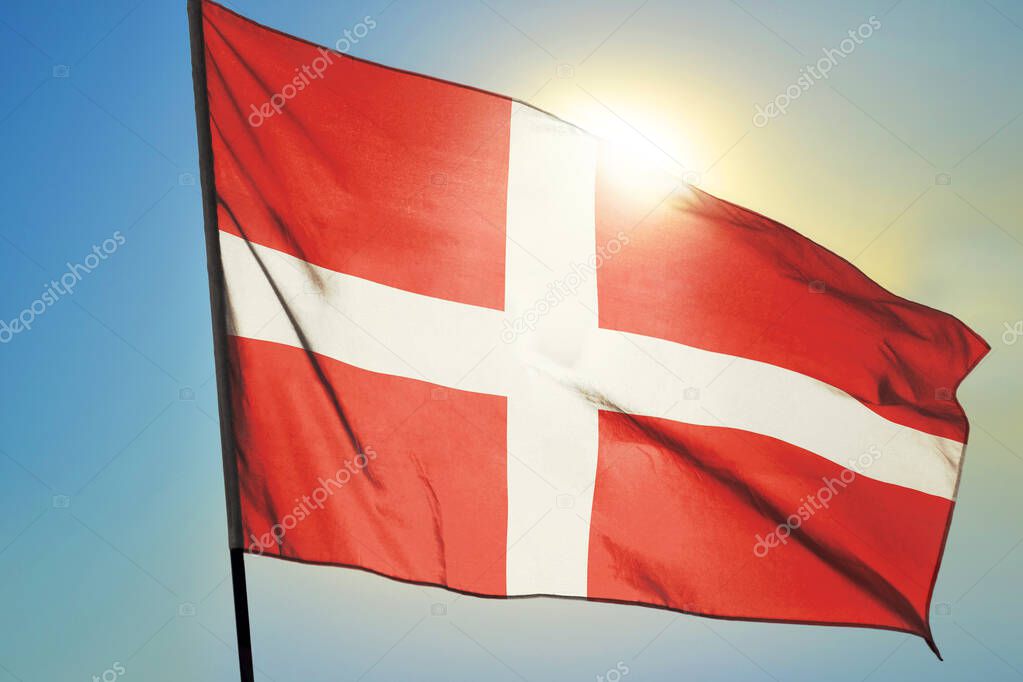 Denmark flag waving on the wind in front of sun