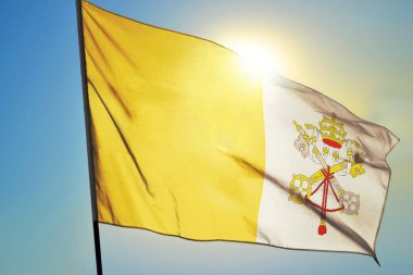 Vatikan şehir bayrağı güneşin önünde rüzgarda dalgalanıyor.