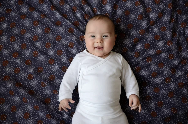 Bambino ragazzo sdraiato e sorridente Foto Stock