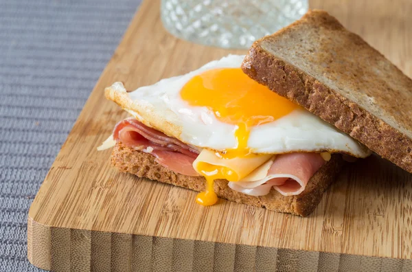 Sahanda yumurta, jambon ve peynir ile kepekli sandviç. — Stok fotoğraf