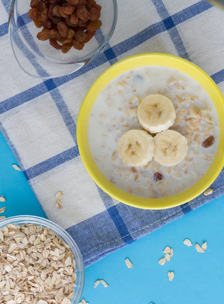 Breakfast porridge with bananas and raisins — Stock Photo, Image