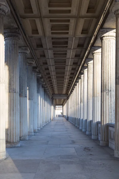 Ein langer gang zwischen vielen säulen in einem historischen gebäude in berlin Stockbild