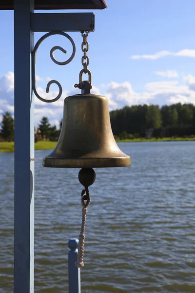 A sea bell on the bridge on the lake, close up