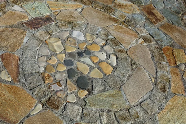 A spiral structure of different stones on the ground