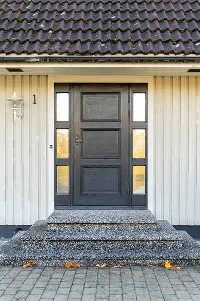 Entrada de casa moderna con puerta de metal gris y escaleras de piedra — Foto de Stock
