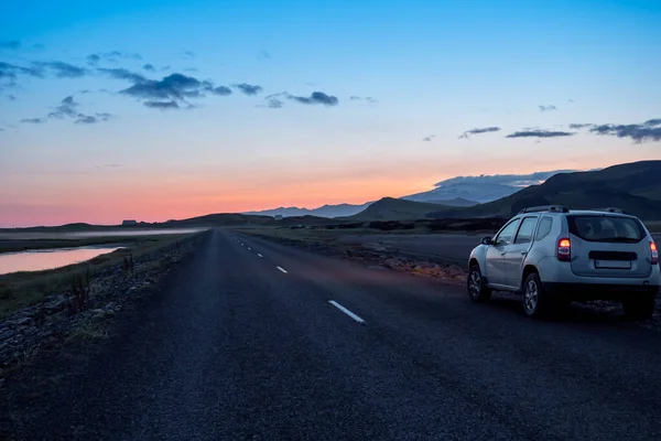 Estrada de cascalho com carro e pôr-do-sol dramático nos fiordes do sul, Islândia — Fotografia de Stock