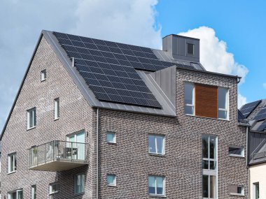 Çatı katında güneş panelleri olan modern bir ev.