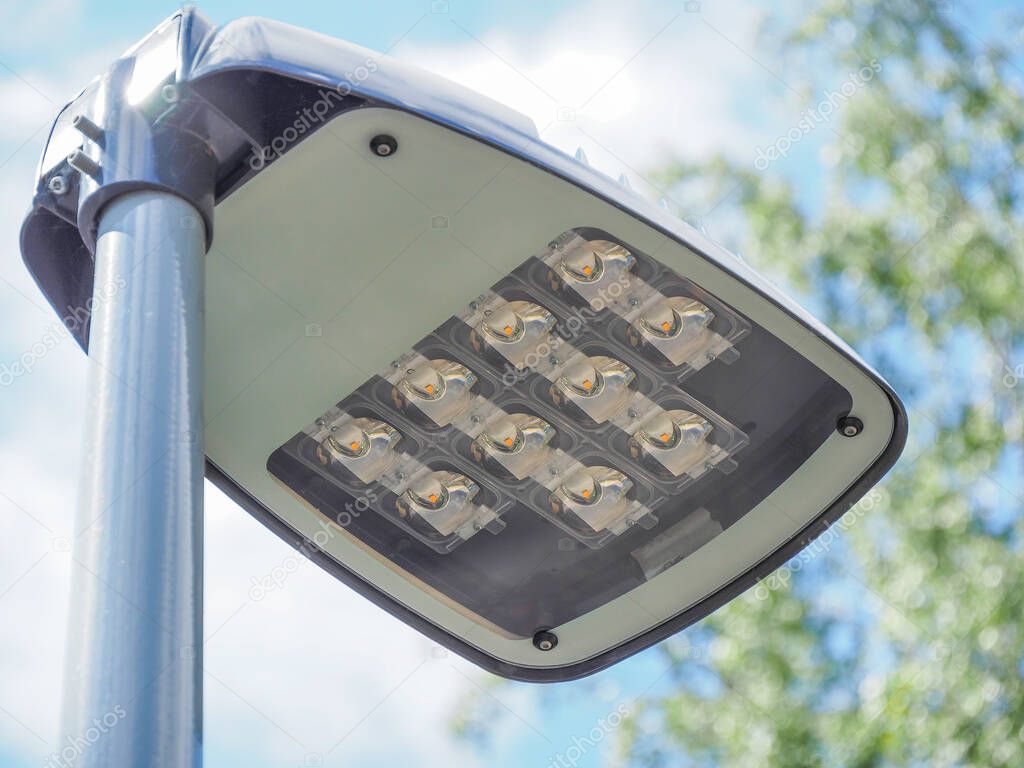 LED street lamp post in details with trees on the background