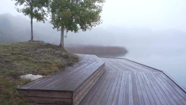 Vue panoramique de la jetée brumeuse du matin sur le lac avec des bateaux en bois — Video