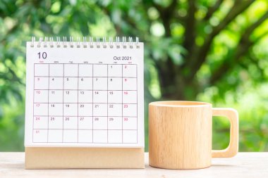 Ekim ayında, Takvim masası 2021 planlama ve hatırlatma için ahşap masa üzerinde yeşil doğa arka planı ile.