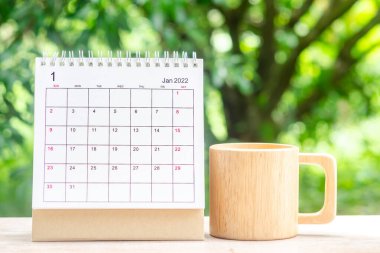 Ocak ayında, Takvim masası 2022 planlama ve hatırlatma için yeşil doğaya sahip ahşap masa üzerinde.